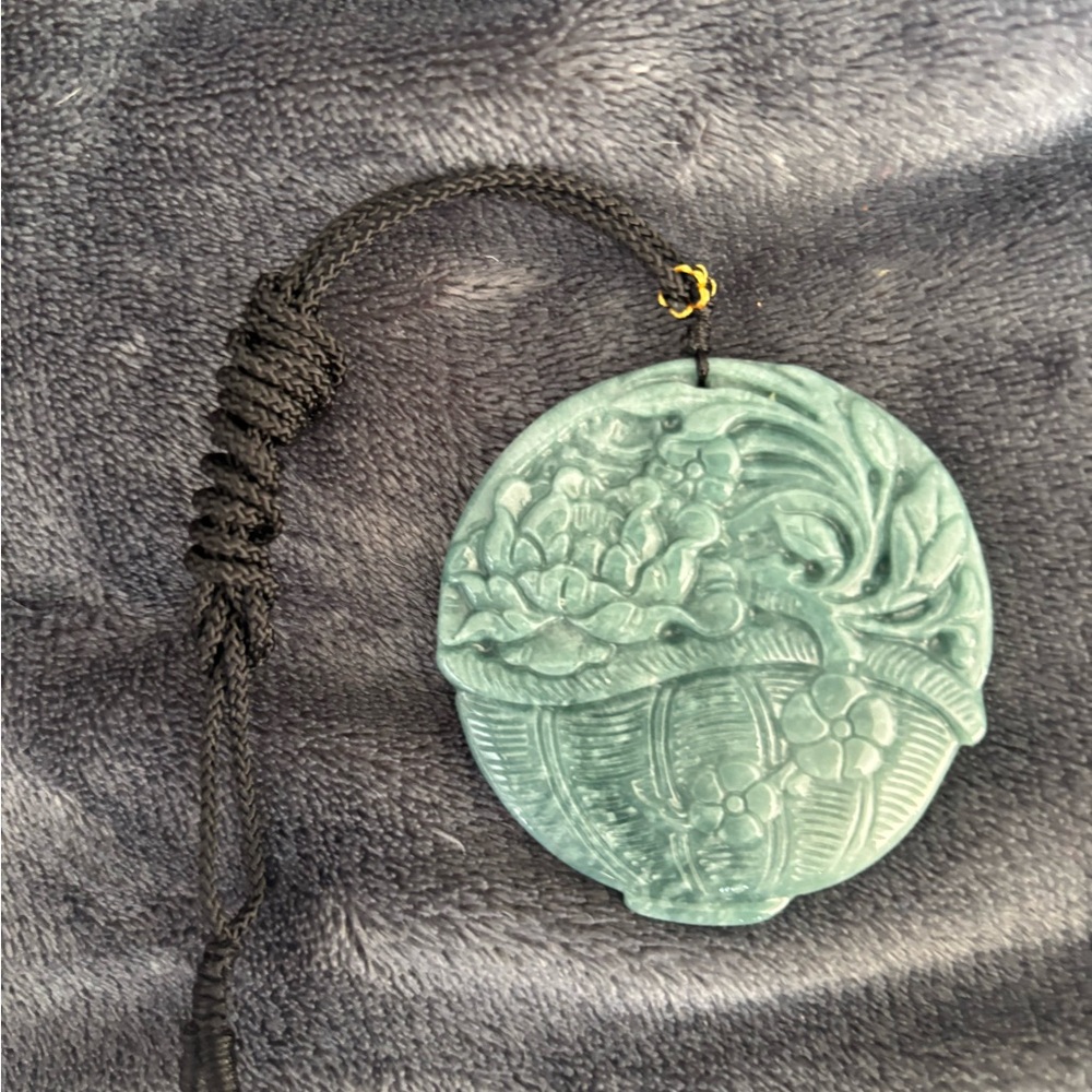 Green Jadeite Pendant featuring carved design of a peony flowers in a basket.